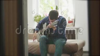 用木吉他演奏音乐的男子吉他手。男子演奏原声吉他近距离慢动作视频。在